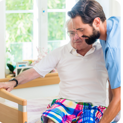 Caregiver lifting Dad into bed
